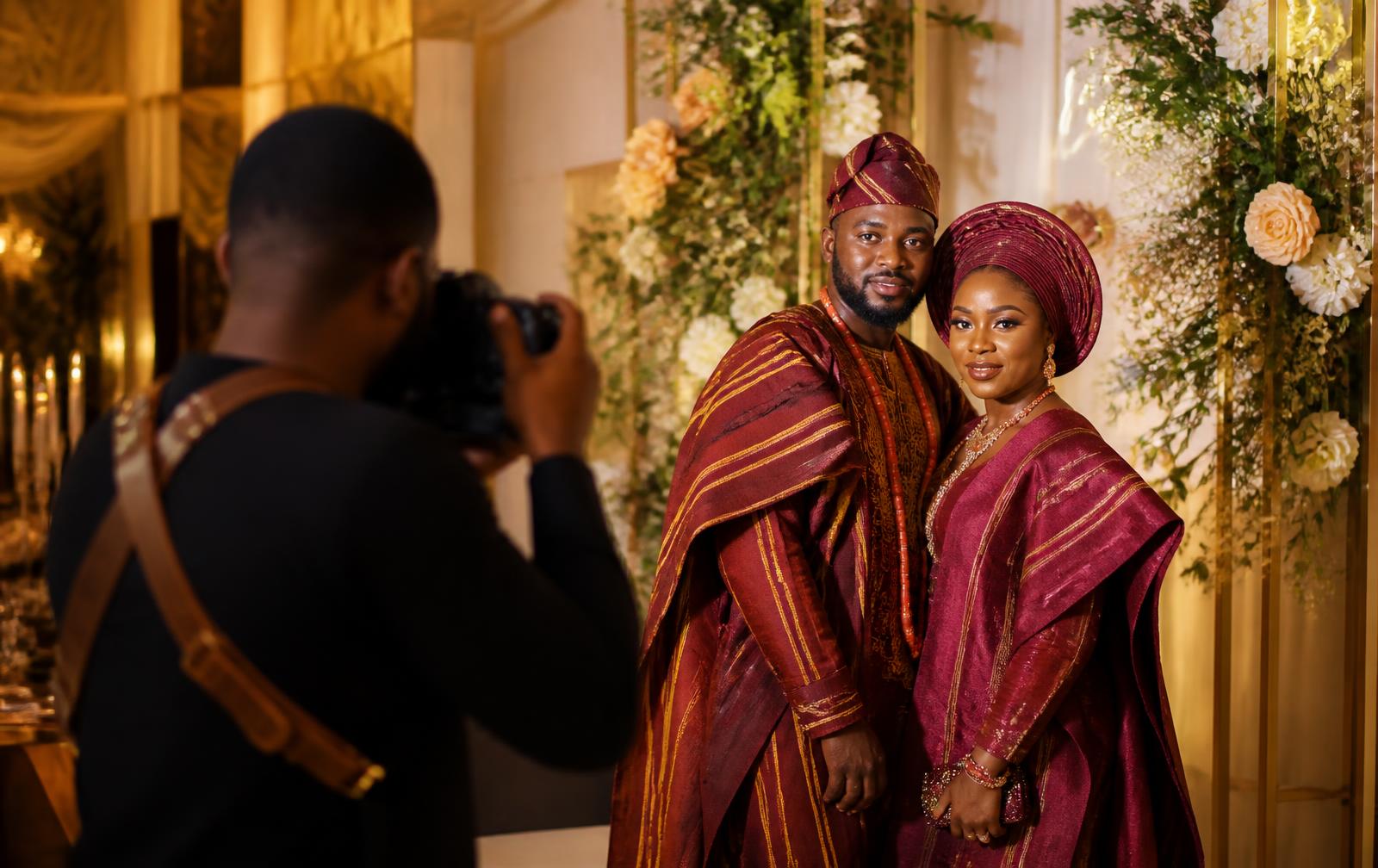 A photographer capturing a Nigerian couple in traditional aso-oke attire at an elegant ceremony